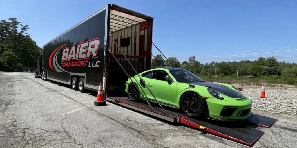 Red Ferrari 488 secured on Baier Transport branded Chevy Silverado 5500 flatbed truck for exotic and luxury car shipping