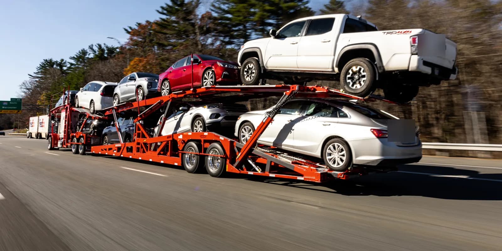 Loaded Baier Transport car carrier on the highway, door to door auto transport