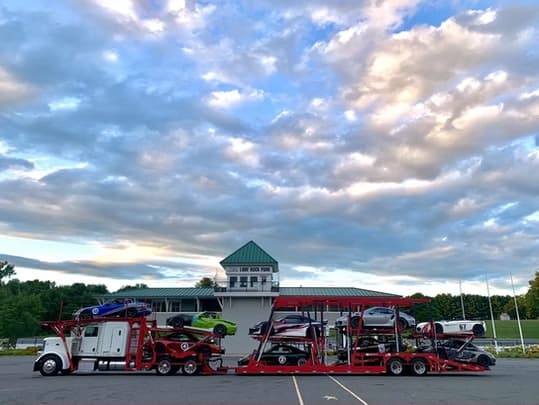 Peterbilt car carrier loaded with race cars and exotic vehicles at Lime Rock Park racetrack in Lakeville Connecticut